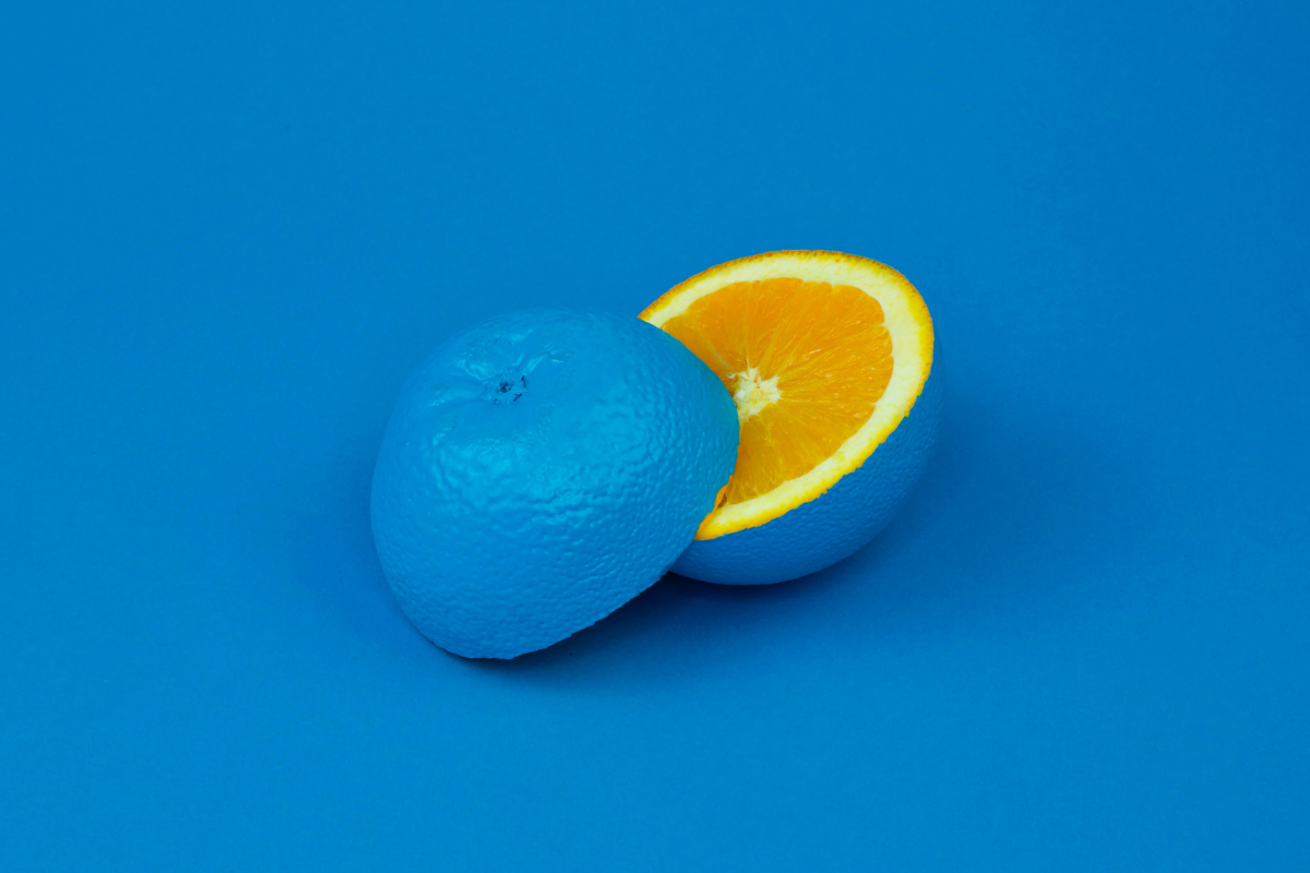 An orange sliced in two, coloured blue