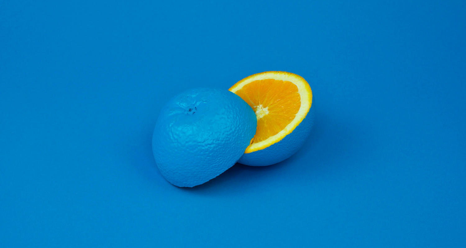 An orange sliced in two, coloured blue